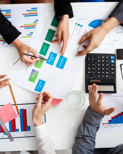Picture of businessmen's hands on white table with documents, coffee and drafts